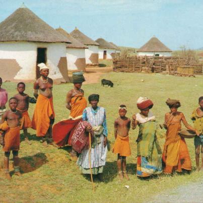 Transkei - Xhosa villagers - with some dressed in the traditional garb of Red Blanket and a woman smoking the characteristic long stemmed pipe